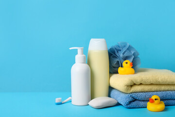 Obraz na płótnie Canvas Baby cosmetic products, bath ducks, accessories and towels on light blue background. Space for text