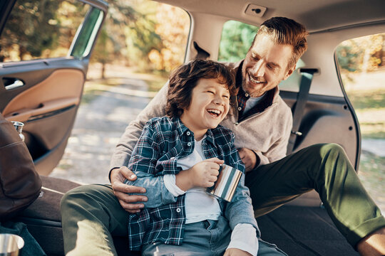 Father and son laughing together in car during a break on road trip
