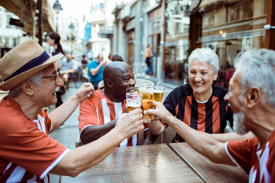Senior football fans drinking beer in the city