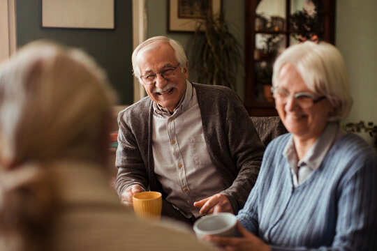 Diverse senior friends talking at home