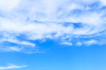 Blue sky background with white clouds, similar to fog covering mountains and waves in the sea.