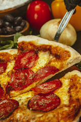 Delectable Pepperoni Pizza Surrounded by Fresh Ingredients