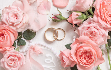 Wedding rings between light pink roses and buds top view, Marriage proposal concep