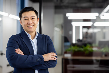 Portrait of successful asian businessman inside office at workplace, man in business suit smiling...