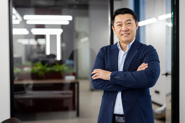 Portrait of successful asian businessman inside office at workplace, man in business suit smiling...