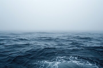 Fototapeta premium An aerial photograph capturing a vast body of water with strong, crashing waves, Atmospheric representation of a foggy ocean with barely visible waves, AI Generated