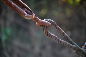 Old, decayed wire, rusted steel sling Rusted wire rope hanging from a bridge But still strong and...