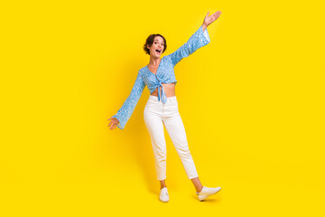 Fototapeta na wymiar Full size photo of cheerful girl wear stylish blouse white pants hand up presenting black friday sale isolated on yellow color background