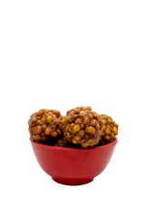 Jaggery Laddu or Gur Ladoo Indian Winter Sweets in a Red Bowl Isolated on White Background with Copy Space