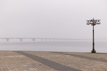 View of the bridge over the river in the fog. Embankment in the fog.