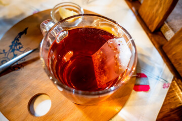 Glass of rose hip tea, tea bag, lemon and honey on table, closeup. - 736427925