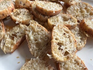 Baked sliced baguette drizzle with olive oil topped with parmigiano reggiano cheese