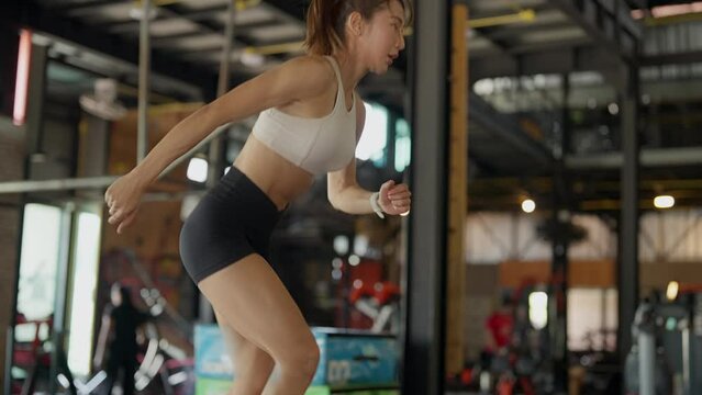 Dynamic image of a focused athletic woman running fast during an indoor workout session at a gym.