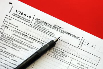 Obraz premium Indonesian tax form 1770 S - 2 Individual Income Tax Return and pen on table close up
