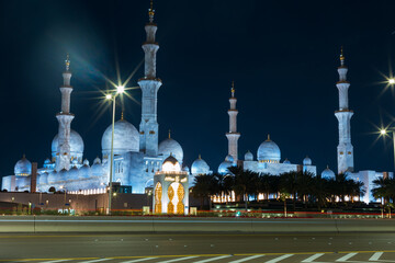 Fototapeta na wymiar Beautiful mosque with lights near the road in Abu Dhabi at night
