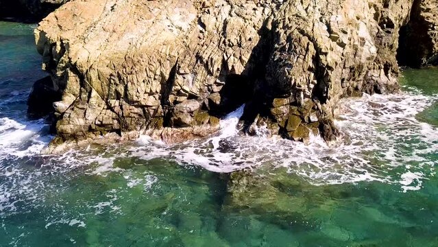 Captivating Coastline: Drone Video of Waves Crashing Against Rock at Seashore