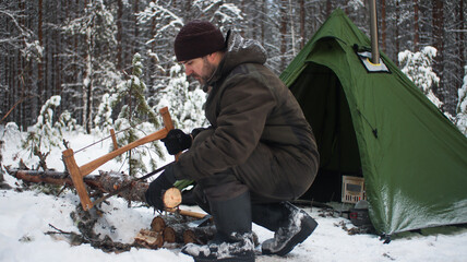 Winter camping in the Boreal Forest. Hot tent. Man stands by a tent. Tepee in the snow. Ecotourism