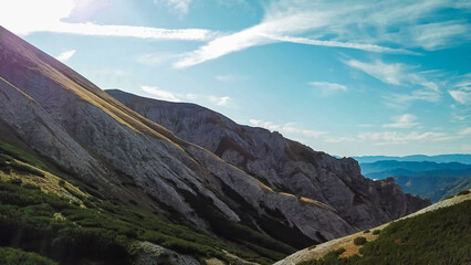 Naklejka premium Panoramic view of majestic mountain cliff Schartenspitze in untamed Hochschwab mountain region, Styria, Austria. Scenic hiking trail in shadows in remote Austrian Alps. Wanderlust in alpine summer