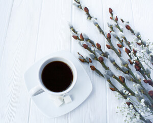 Coffee cup and spring  flowers on the white wooden background. Close-up.