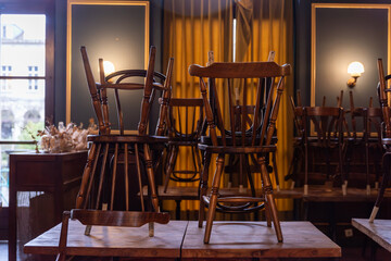 Chairs in the restaurant placed on the table, cleaning in the restaurant, chairs arranged