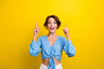 Photo of impressed funky woman wear flower print blouse showing two fingers empty space isolated yellow color background - obrazy, fototapety, plakaty