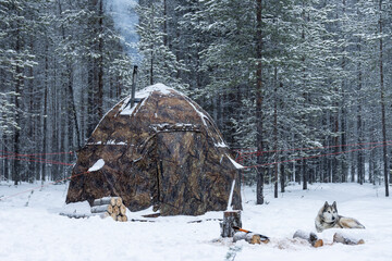 Winter camping in a hot tent. Wilderness in cold weather.