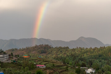 A beautiful rainbow above the green hills in the Himalayan village of Chaukori in Uttarakhand.