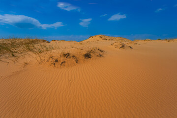 Fototapeta na wymiar wide sandy desert under blue cloudy sky