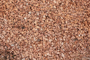 Red gravel, crushed stone, small stones, gravel texture stones background. small stones in the background. red gravel texture,