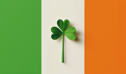 St. Patrick's Day celebration. Green shamrock leaf isolated on Ireland flag background. Minimalistic composition. Traditional Irish holiday in March