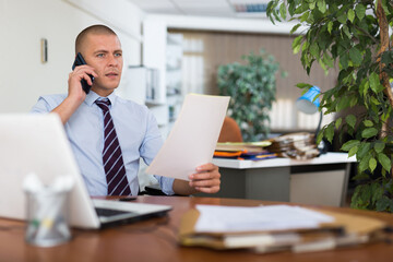 Businessman having phone call conversation at workplace in office