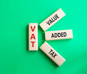 VAT - Value Added Tax symbol. Wooden cubes with word VAT. Beautiful green background. Business and Value Added Tax concept. Copy space.