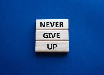 Never give up symbol. Concept words Never give up on wooden blocks. Beautiful deep blue green background. Business and Never give up concept. Copy space.