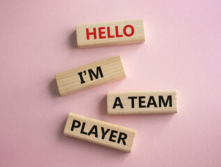 Hello I am a team player symbol. Concept words Hello I am a team player on wooden blocks. Beautiful pink background. Business and Hello I am a team player concept. Copy space