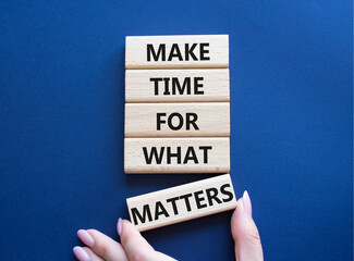 Important thing symbol. Wooden blocks with words Make time for what matters. Businessman hand. Beautiful deep blue background. Business and important thing concept. Copy space.