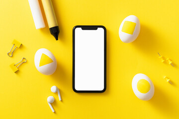 Blank screen smart phone with clipping path on yellow Easter background.