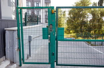 Front door of the courtyard. Metal Wire Fence.Green metal driveway entrance gates. Remote control...