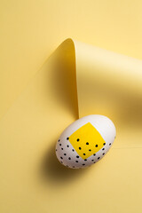 Yellow painted easter egg on yellow background