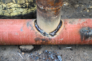 Welded tee joint with some defects. Two metal pipes welded together in T-joint