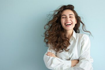 Copy space of a young entrepreneurial businesswoman, smiling and cheerful against a light blue background, white shirt, and tousled hair - obrazy, fototapety, plakaty