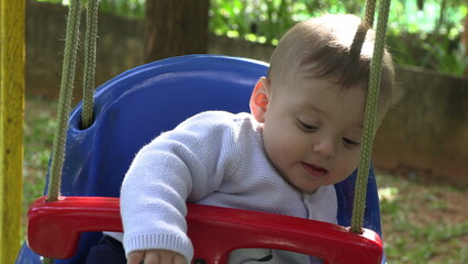Fototapeta na wymiar Adorable cute baby infant at playground swing