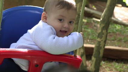 Fototapeta na wymiar Baby boy at playground swing