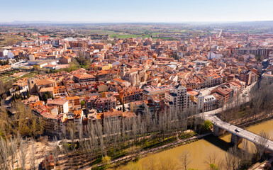 Drone view of Aranda de Duero cityscape on river banks in spring overlooking terracotta tiled roofs...