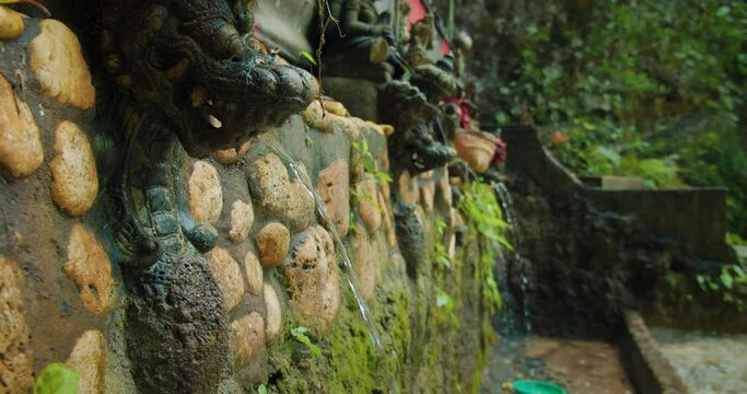 Balinese temple wall with Ancient Guardians as fountains. The Stone Carvings in Nusa Penida, Bali, Indonesia.