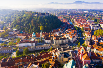 View from drone of historical center of Slovenian city of Ljubljana with medieval castle on Castle Hill in autumn morning