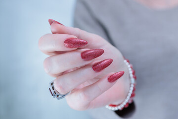 Female hands with long nails and dark red nail polish
