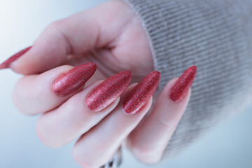 Female hands with long nails and dark red nail polish
