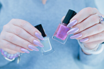 Woman hand with long nails manicure and light blue and pink nail polish