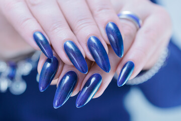 Woman's beautiful hand with long nails and dark blue manicure