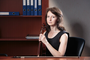 A woman with a violin in the office. - 736509100